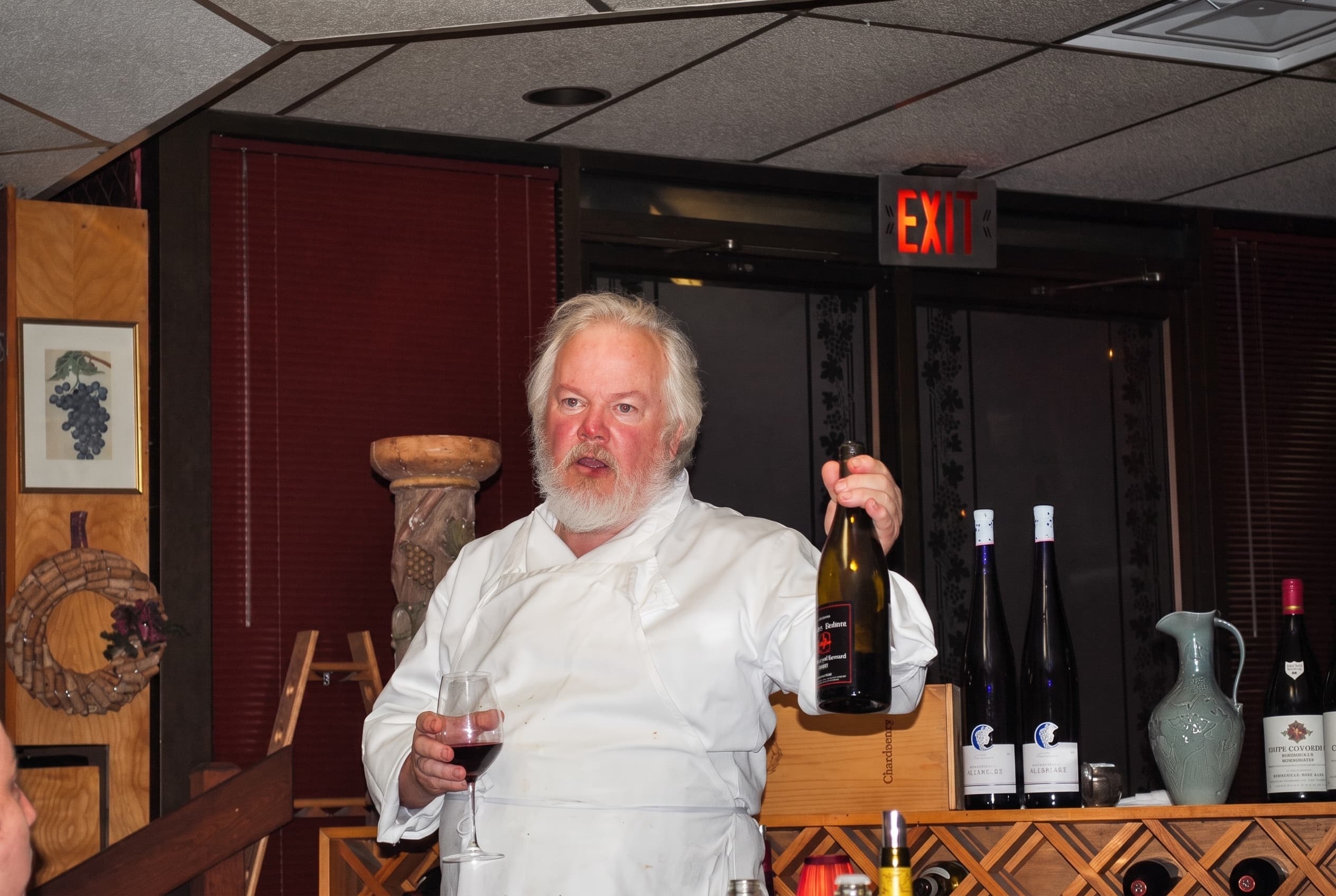 Bill Curtis presenting a bottle to a private dinner at the big table