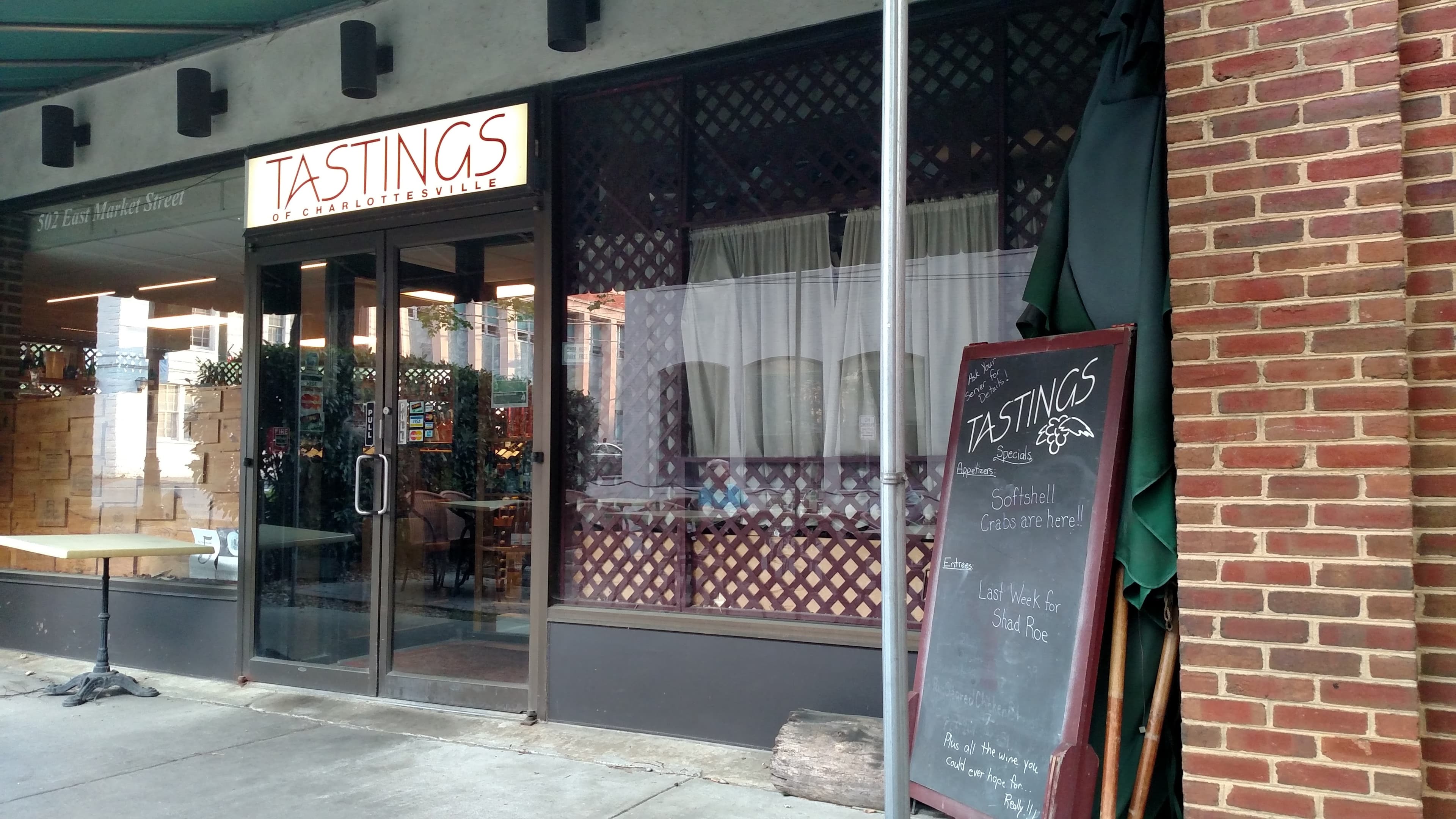 The Tastings storefront under the Market Street garage: gold sign, wine crates in the window, sidewalk chalkboard