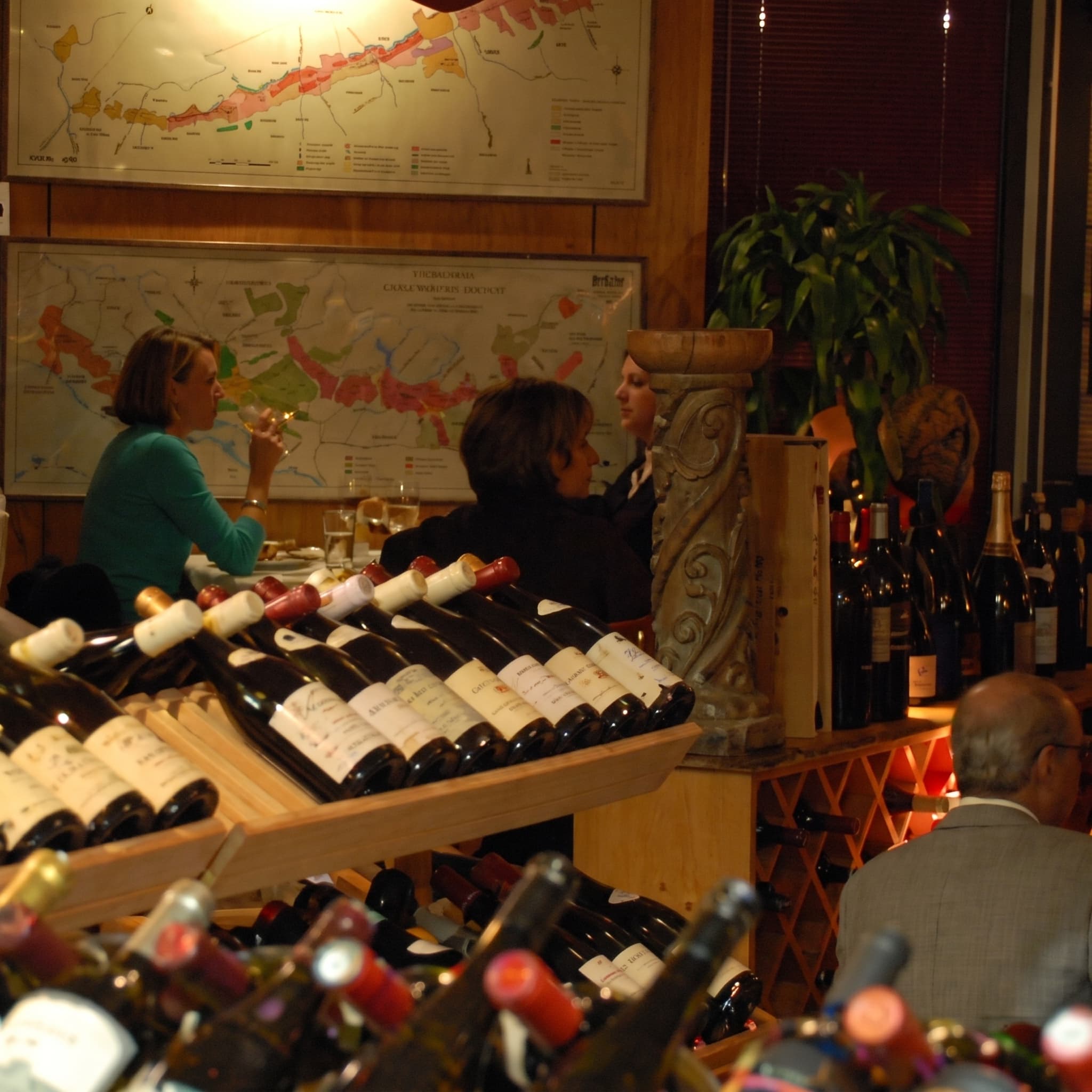 Lunch service among the wine racks, Burgundy maps framed on the wall