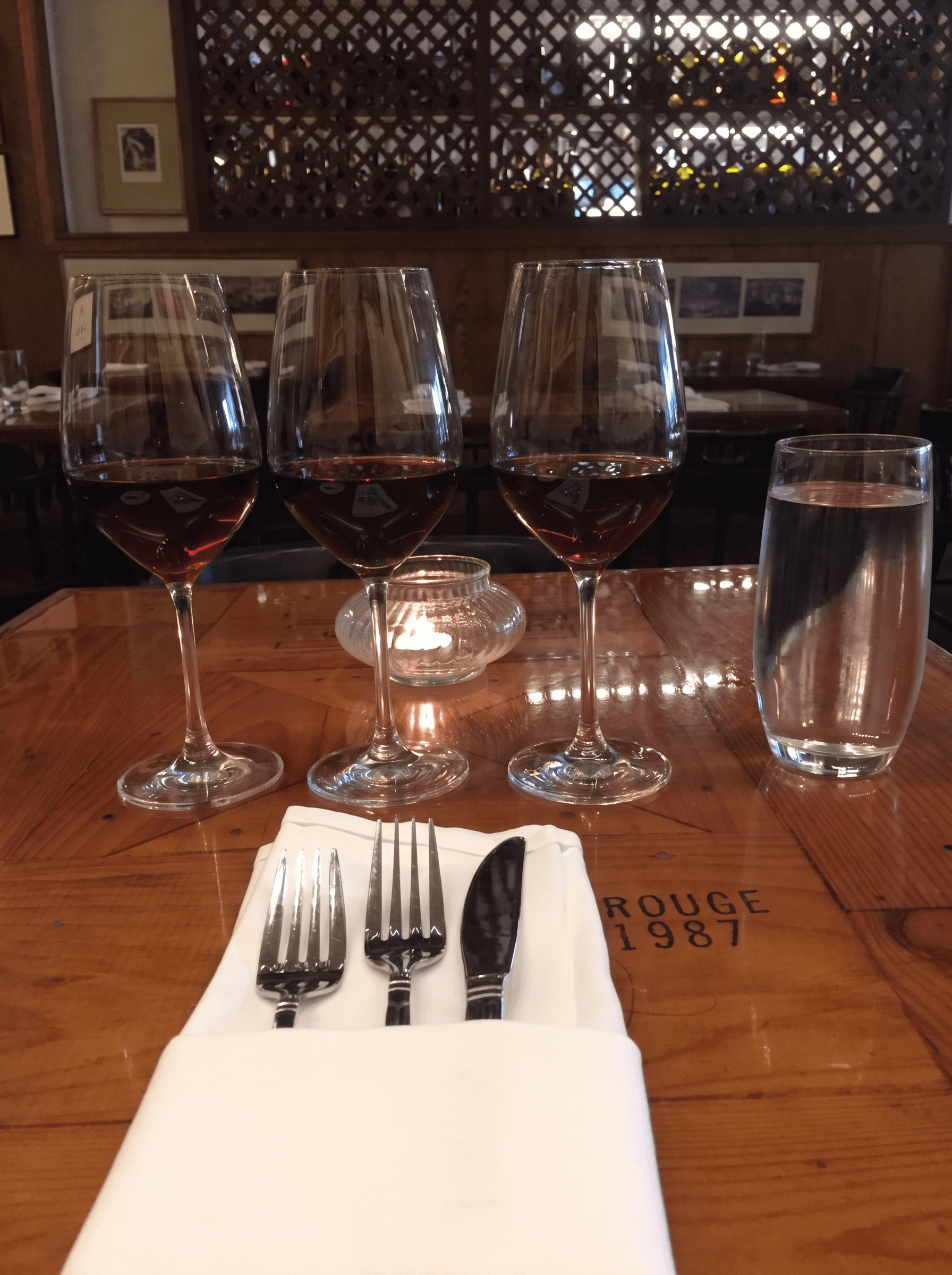 A wine flight lined up on a crate-lid table at Tastings
